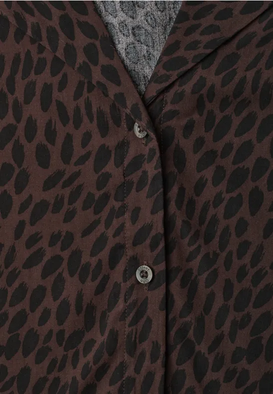 Braune Jacke mit schwarzem Blattmuster, zwei Knöpfe, grauer Pullover sichtbar