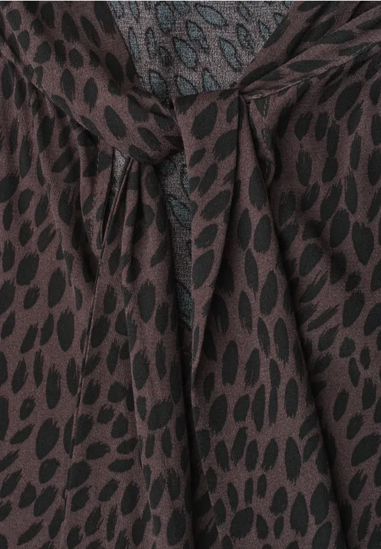 Braune Bluse mit schwarzem Blattmuster und dekorativem Knotendetail am Ausschnitt.