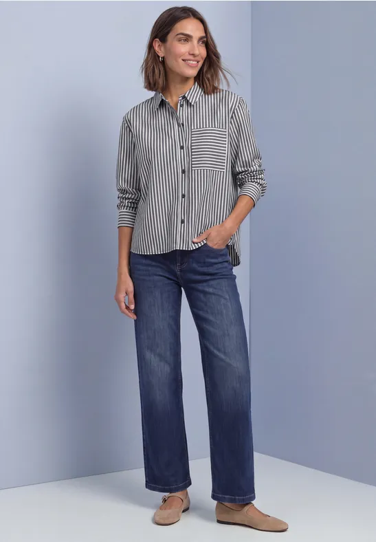 Femme en chemise rayée, jean large et chaussures plates