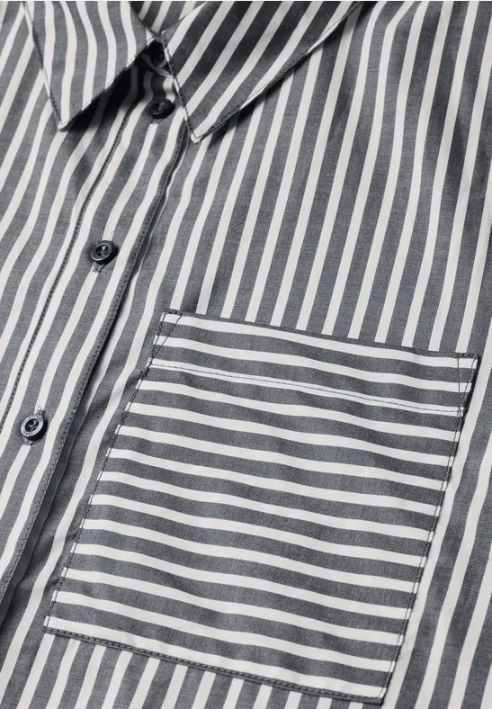 Gros plan d'une chemise à rayures grises et blanches avec poche poitrine.