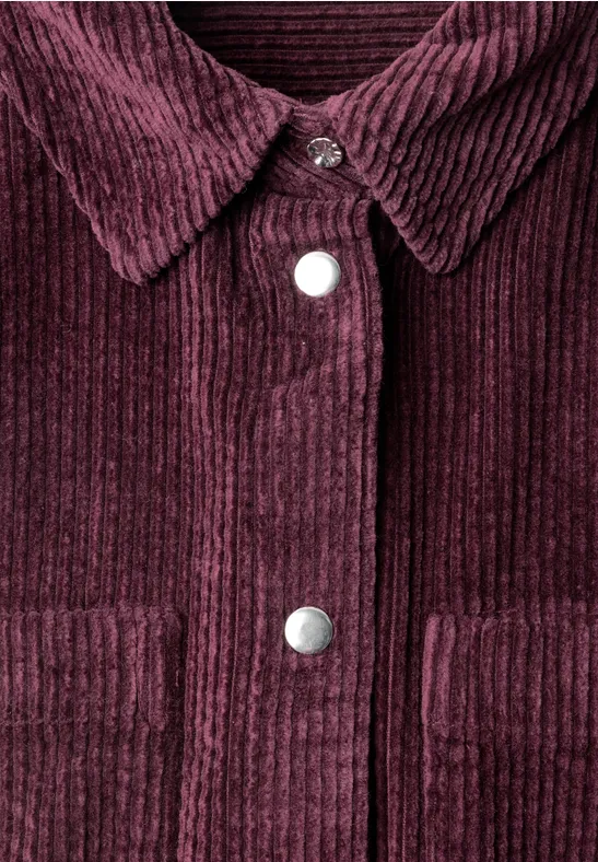 Bordeauxrotes Cordjackett mit silbernen Druckknöpfen, Kragen und aufgesetzten Taschen.