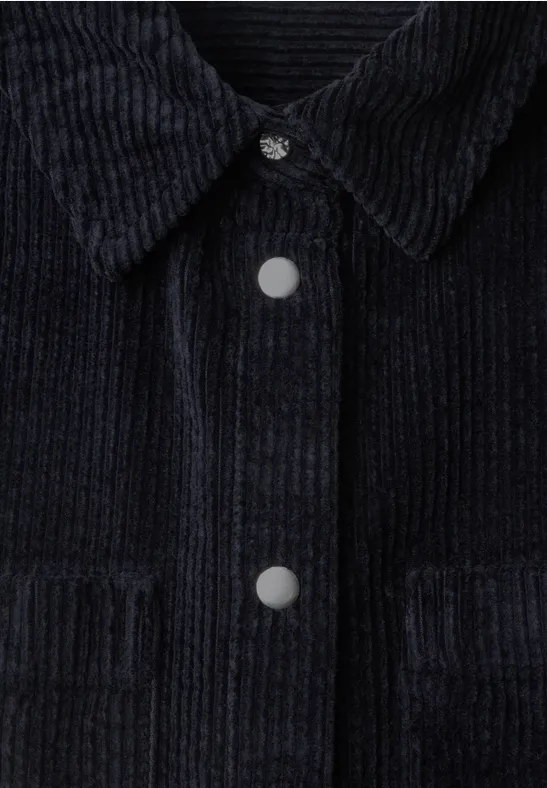 Schwarze Cordjacke mit Kragen, Metall-Druckknöpfen und Brusttaschen, feine Rippenstruktur.