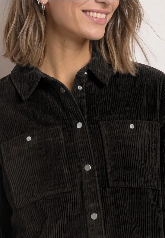 Damen-Cordjacke in Schwarz mit Kragen, Druckknöpfen und aufgesetzten Brusttaschen.