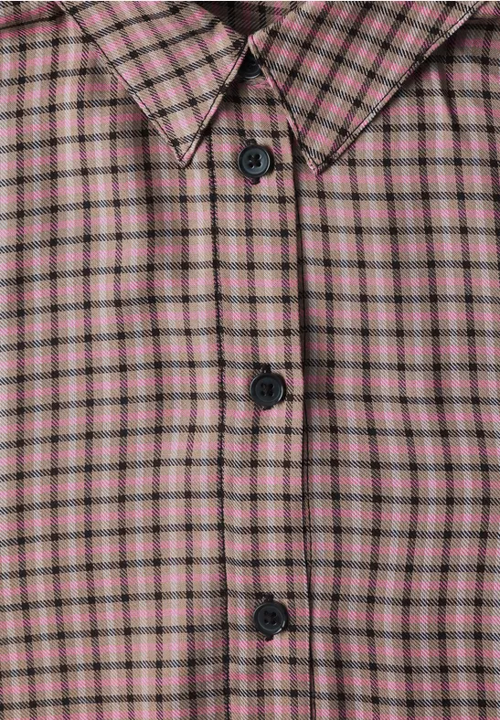 Nahaufnahme eines karrierten Hemdes in Rosa und Grün mit schwarzen Knöpfen