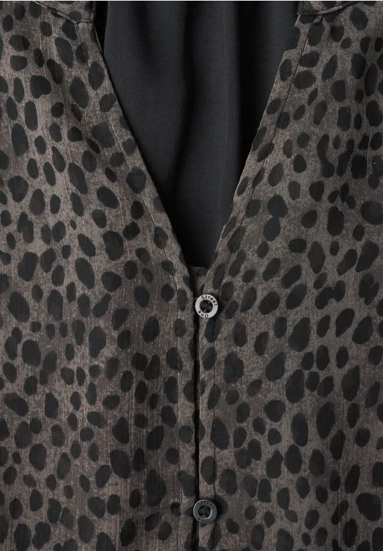 Getupfte Jacke mit schwarz-grauem Leopardenmuster und Knöpfen.