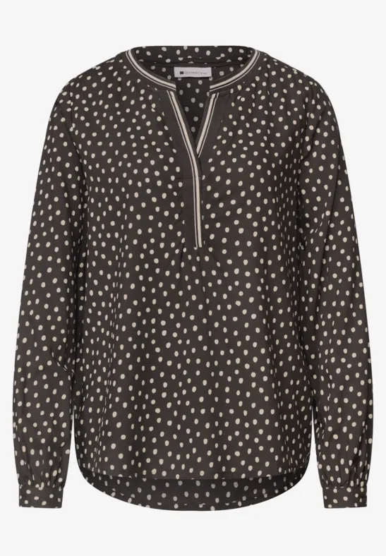 Schwarze Bluse mit cremefarbenen Tupfen, V-Ausschnitt, langen Ärmeln und abgerundetem Saum.