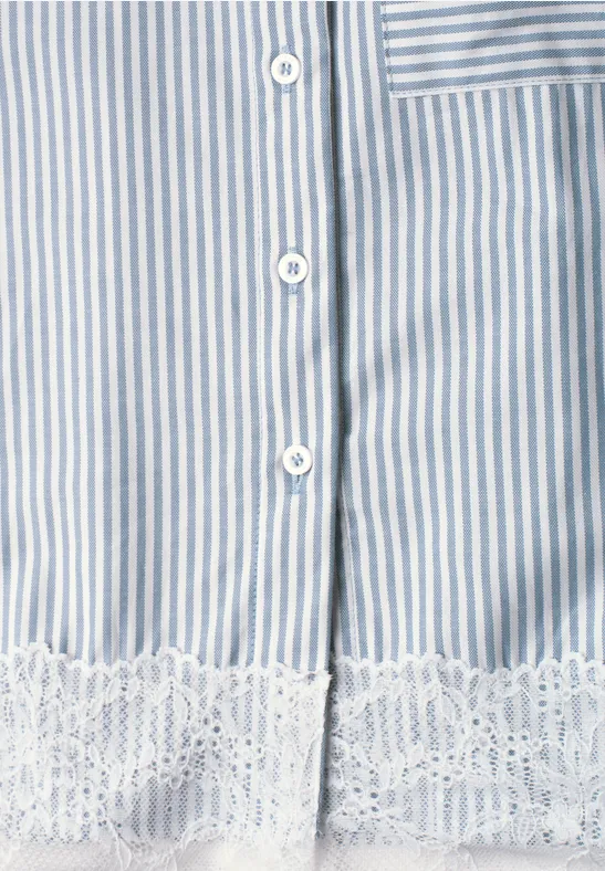 Nahaufnahme eines blau-weiß gestreiften Kleidungsstücks mit weißen Knöpfen und Spitzenbesatz