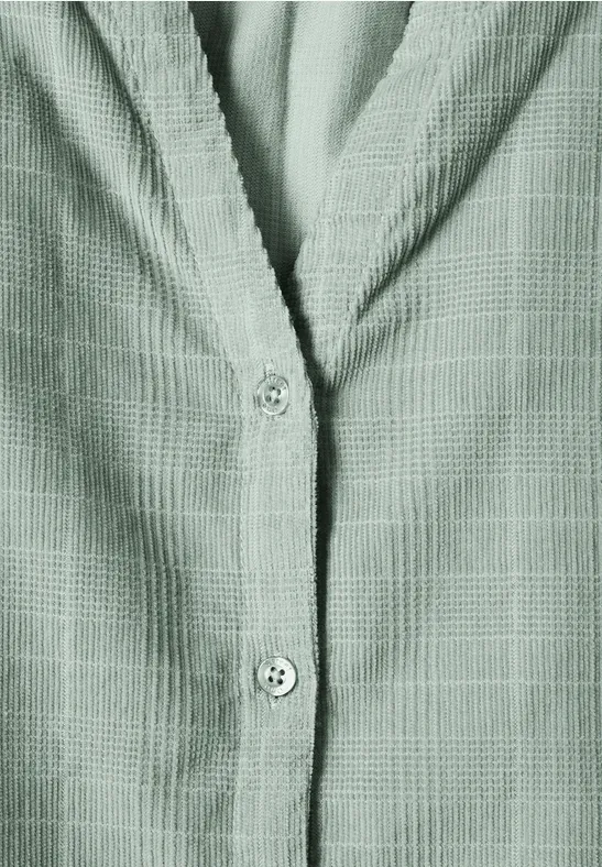 Grünes Hemd mit feinem Karomuster und Knopfleiste, Detailaufnahme von Vorderseite und Kragen.