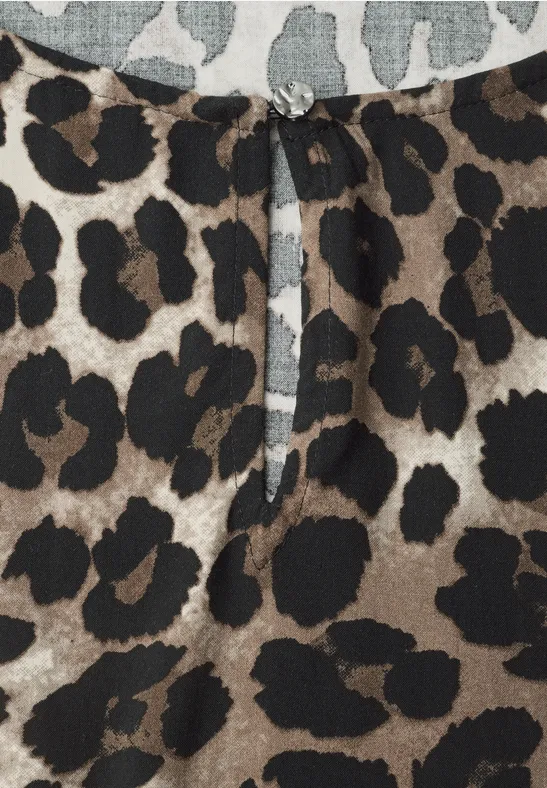 Damenbluse mit braun-schwarzem Leopardenmuster und kleinem Keyhole-Ausschnitt mit funkelndem Zierknopf.
