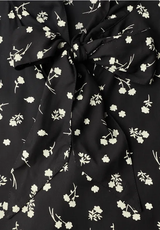 Schwarzer Stoff mit zarten weißen Blüten und Knoten-Detail