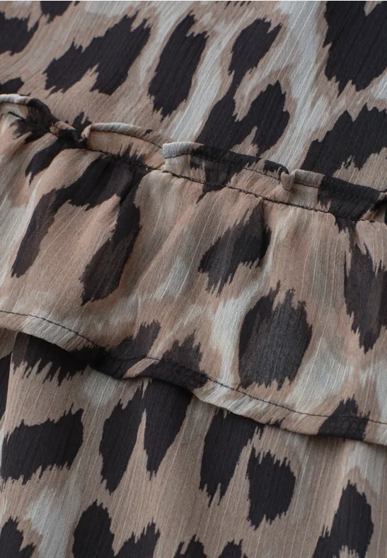 Nahaufnahme eines Leopardenmusters auf leichtem, chiffonähnlichem Stoff mit Rüschenkante.