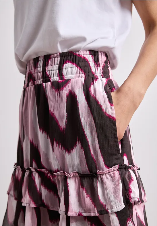 Jupe à volants en couches avec motif abstrait noir, blanc et rose et taille élastique.