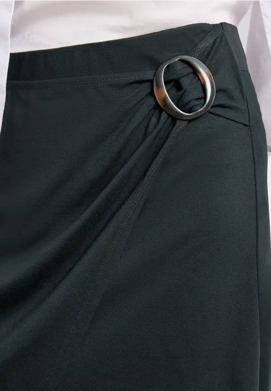 Schwarzer Wickelrock mit großer silberner Ringschnalle an der Seite.