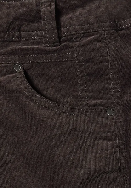Gros plan d’un pantalon en velours côtelé marron foncé avec poche avant.