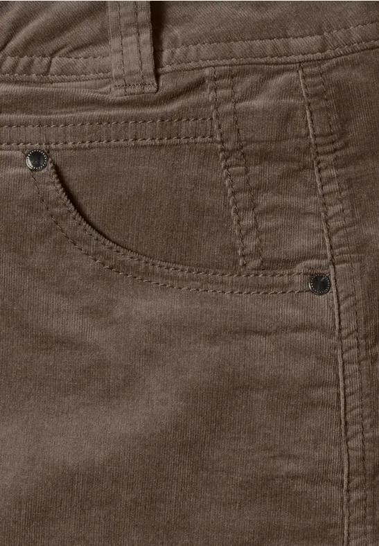 Nahaufnahme einer braunen Cordhose mit Tasche, sichtbaren Nähten, Gürtelschlaufen und Metallnieten.