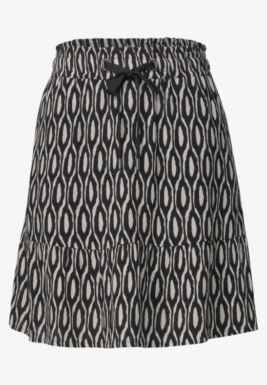 Korte zwarte rok met wit organisch patroon, elastische tailleband en sierstrik aan de voorkant.