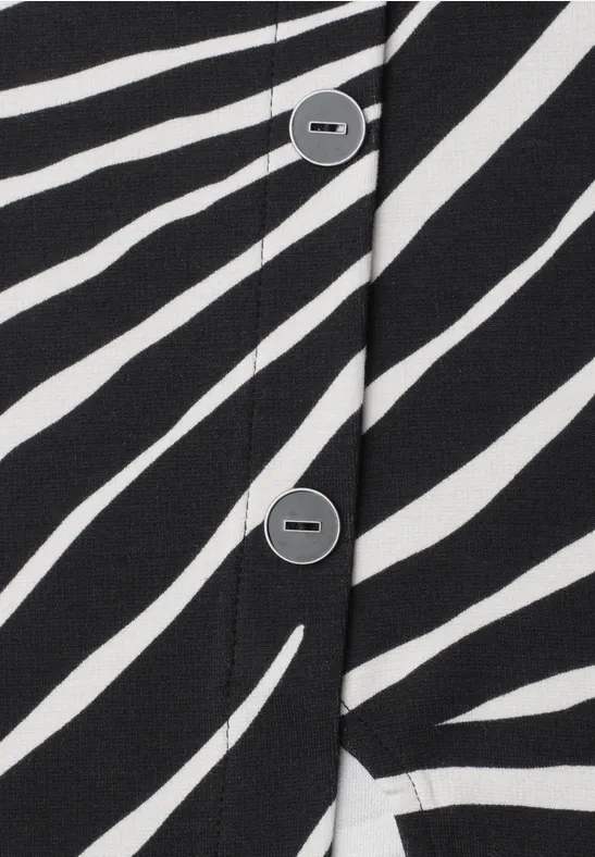 Gros plan d'un tissu à rayures noir et blanc avec une patte de boutonnage et des boutons gris.