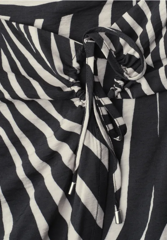 Zwart-witte stof met zebraprint en knoopkoord in de taille.