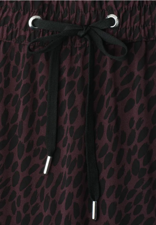 Dunkelroter Stoff mit schwarzem Leopardenmuster und Schnürbund.