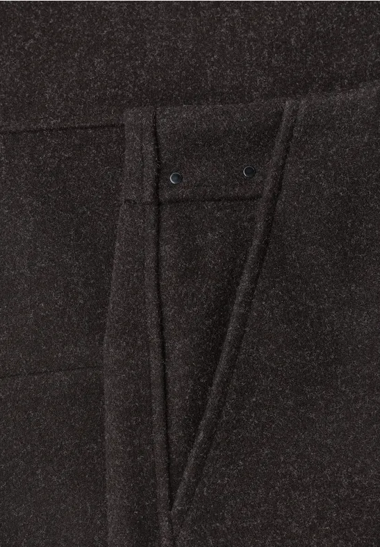 Nahaufnahme einer schwarzen Hose mit eingenähter Tasche und feinen Ziernähten.