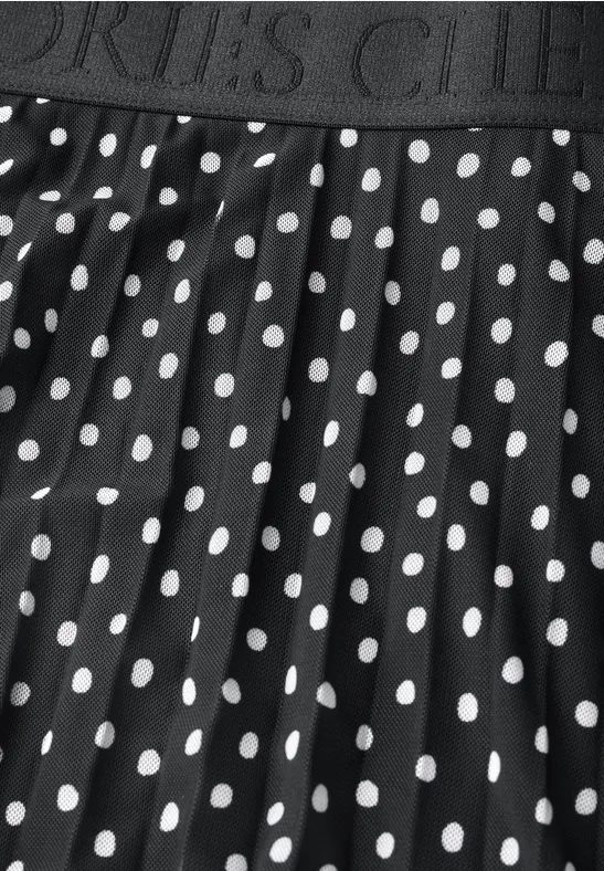 Ein schwarzer Rock mit weißem Polka-Dot-Muster und elastischem Bund mit Aufschrift 'SPORTS CLUB'.