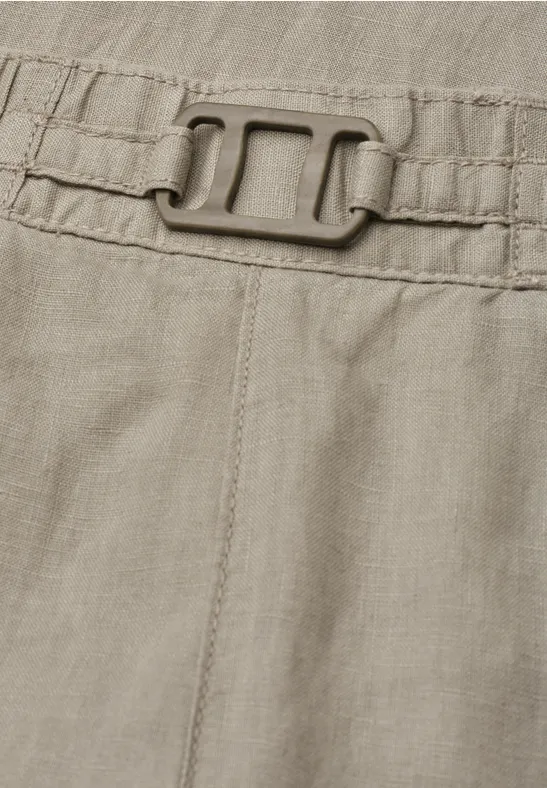 Close-up van een kaki kledingstuk met elastische tailleband en gesp.