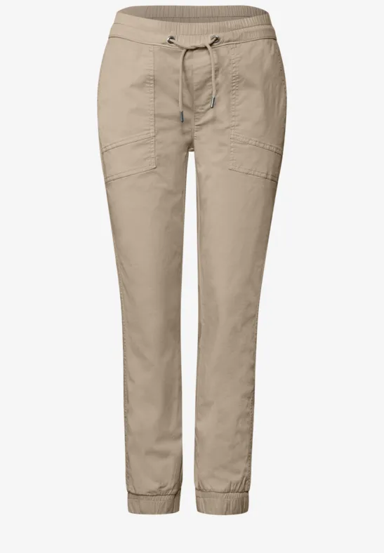 Licht beige vrijetijdsbroek met elastische taille, trekkoord en elastische boorden aan de pijpen.