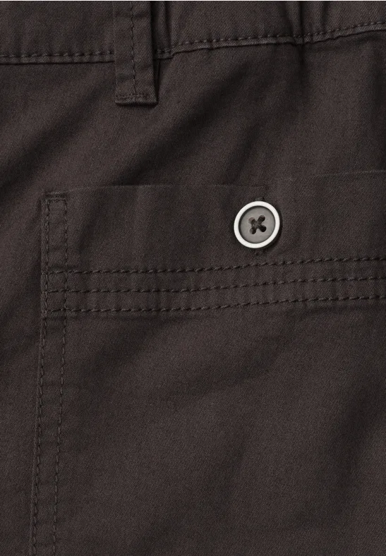 Close-up van een donkerbruine stoffen zak met klep en ronde knoop.