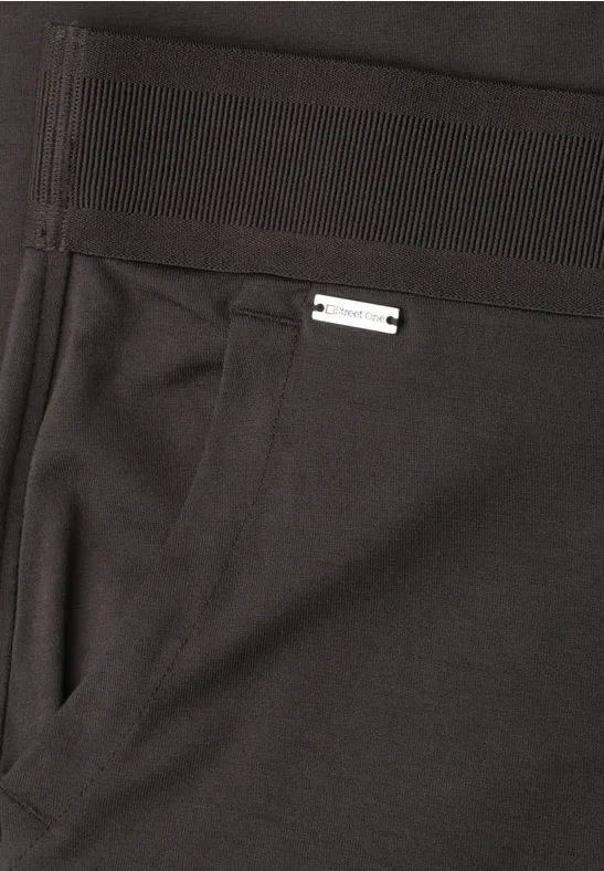 Schwarze Hose mit seitlicher Tasche und kleinem silbernem Label oberhalb der Tasche.
