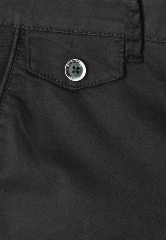 Detailaufnahme einer schwarzen Hose mit Klappentasche und Knopfverschluss.