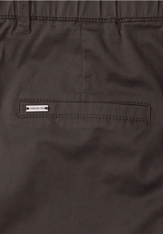 Nahaufnahme einer dunklen Hose mit Gesäßtasche und kleinem Markenlabel.