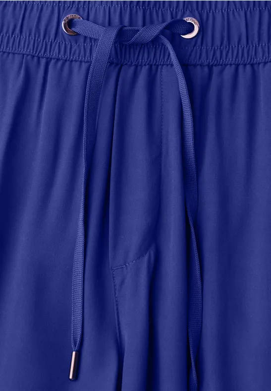 Blauwe sportbroek met trekkoord aan de elastische tailleband.