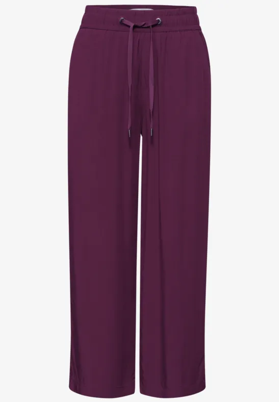 Losse bordeauxrode damesbroek met wijde pijpen en trekkoord in de taille voor comfort.