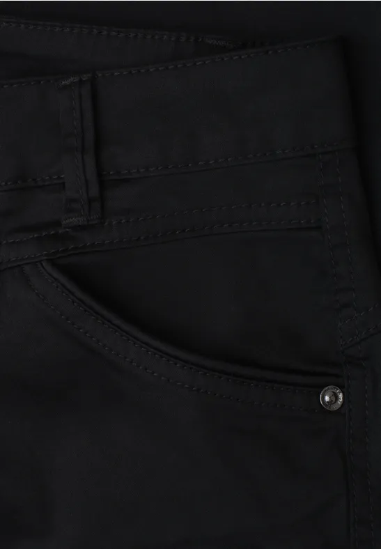 Schwarze Jeans-Tasche mit sichtbaren Nähten und Metallniete.