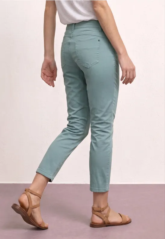 Persoon met muntgroene, enkelhoge broek en bruine sandalen.