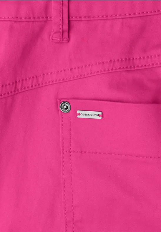 Felroze broek met zichtbare achterzak en klein metalen logo bij de taille.