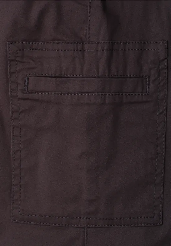 Bruine stof met vierkante opgestikte zak en decoratieve naden