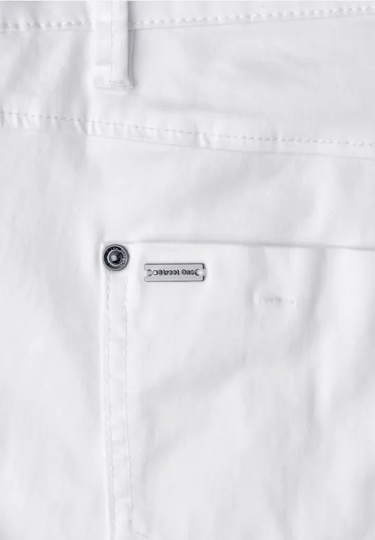 Close-up van een witte spijkerbroek met opgestikte zak, klinknagel en klein merkteken.