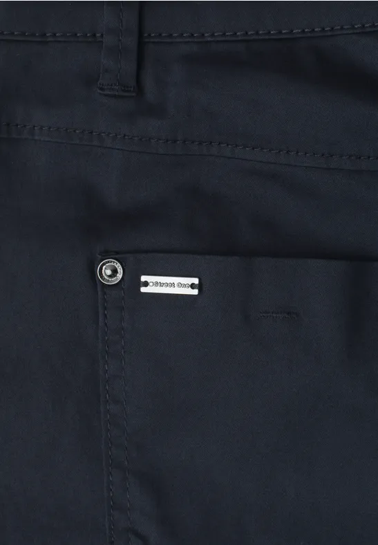 Nahaufnahme einer dunkelblauen Hose mit einer aufgesetzten Tasche und seitlichem Markenlabel.