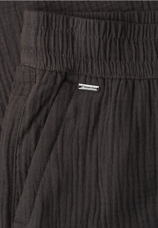 Schwarz gerippte Hose mit elastischem Bund, seitlicher Tasche und kleinem Metall-Label.