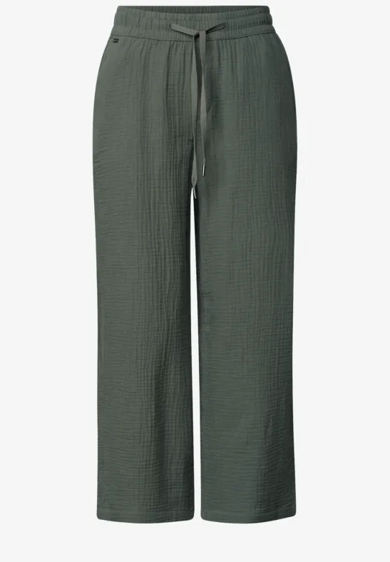 Donkergroene, wijdvallende broek van textuurstof met elastische taille en trekkoord.