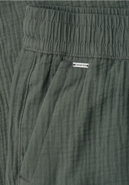Donkergroene broek van licht gekreukt katoen met elastische taille en zijzak.