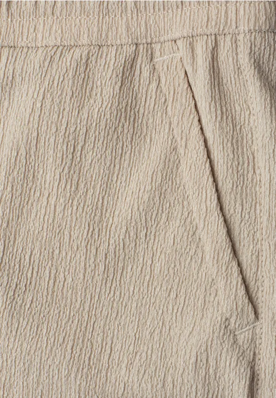 Beige Hose aus strukturierter Baumwollmischung mit elastischem Bund und seitlicher Tasche.