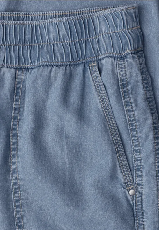 Lichtblauwe denimstof met elastische tailleband en zijzak.