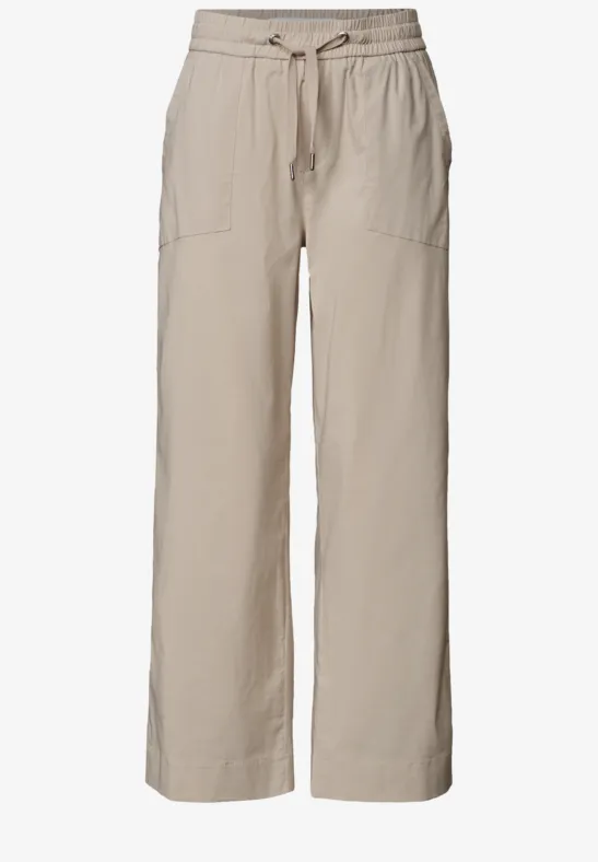 Helle, beige Leinenhose mit weitem Bein, Tunnelzugbündchen und aufgesetzten Taschen.
