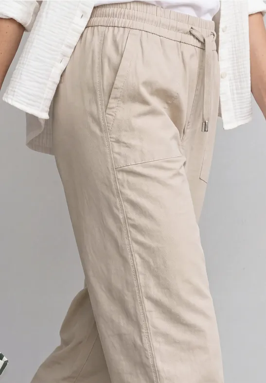 Helle beige Leinenhose mit Tunnelzugbund und Seitentaschen.