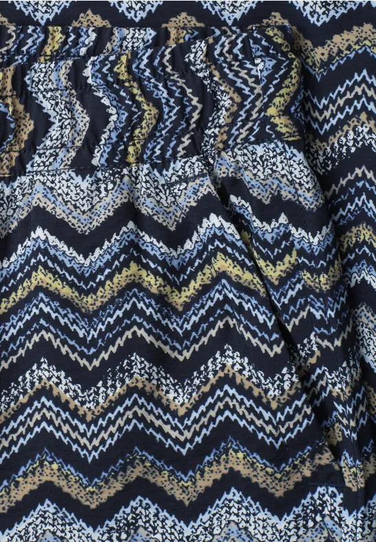 Nahaufnahme eines Stoffes mit Zickzackmuster in Blau, Weiß, Gelb und Schwarz.