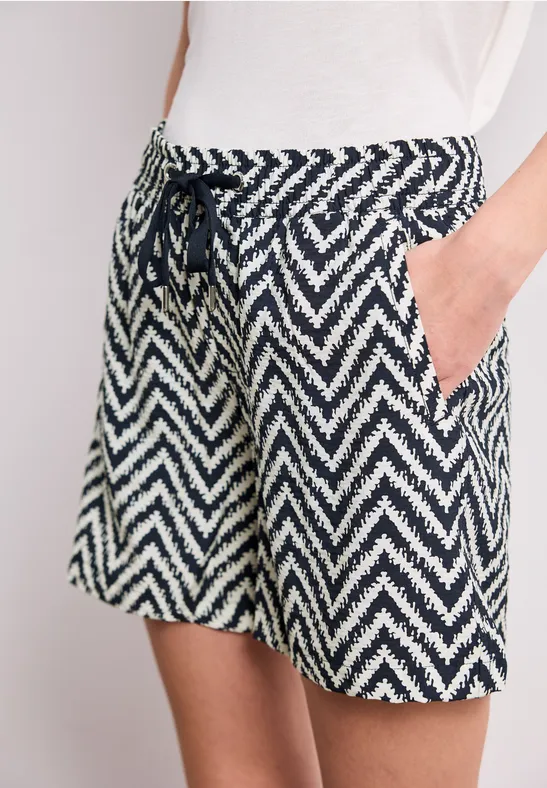 Frau trägt lässige Shorts mit navy-weißem Zickzack-Muster und Tunnelzug mit Kordel.