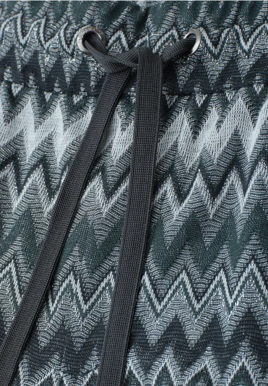 Gebreid zigzagpatroon in groen-, grijs- en zwarttinten met een zwarte koord centraal.