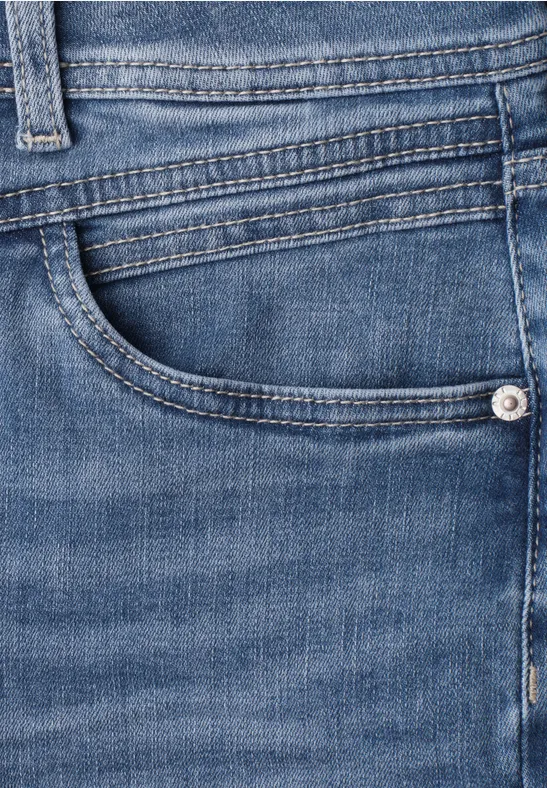Nahaufnahme einer blauen Jeans mit sichtbarer Vordertasche und Nahtdetails.